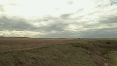 Volando-Sobre-El-Campo-Con-Un-Tractor-Agrícola-Sembrando-En-Saskatchewan,-Canadá