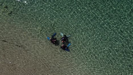 Aerial-view-of-divers-in-shallow-water-getting-ready-to-go-scuba-diving