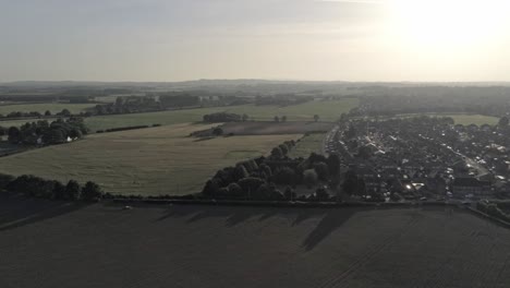 Aerial-view-across-golden-hour-rural-British-countryside-farmland-agriculture-growth-sunrise-shadows