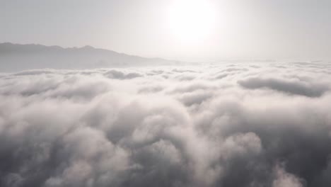Dramatic-clouds-over-Xianggong-Mountain-in-China,-aerial-view-above-clouds