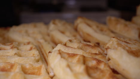 Freshly-made-golden-brown-waffles-ready-for-a-family-breakfast---sliding-close-up