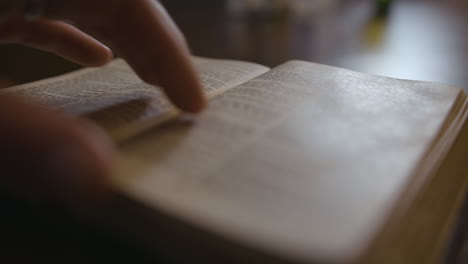 Nahaufnahme-Einer-Bibel,-Die-Auf-Einen-Tisch-Gelegt-Wird-Und-Seiten-Durchgeblättert-Werden