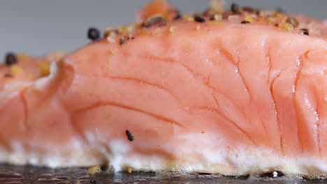 Beautiful-fresh-salmon-fillet-cooking-and-seasoned-on-hot-pan,-macro-closeup