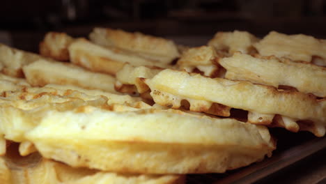 Stack-of-fresh-golden-waffles-hot-and-ready-to-eat---sliding-isolated-close-up