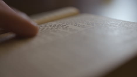 Extreme-Nahaufnahme-Der-Bibel,-Während-Jemand-Durch-Die-Seiten-Fingert-Und-Liest