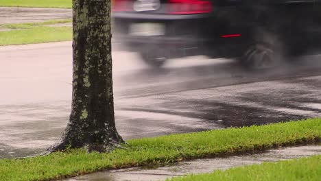 Auto-Fährt-Nasse-Straße-Hinunter,-Während-Es-In-Zeitlupe-Regnet