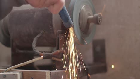 Metal-grinding-machine-making-sparks-while-grinding-a-piece-of-metal-in-a-workshop