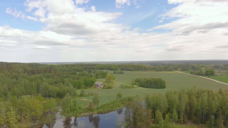 Bird's-view-over-lake-of-beautiful-park-in-Kurzeme,-Latvia,-cloudy-day