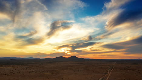 Goldener-Wüsten-Hyperlapse-Mit-Bunten-Wolkenfetzen,-Die-In-Einem-Traumhaften-Sonnenuntergang-über-Den-Himmel-Fließen