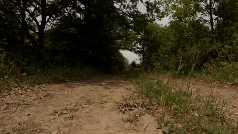 Shot-of-a-boy-cycling-a-white-mountain-bike-towards-the-camera-on-a-dirt-road