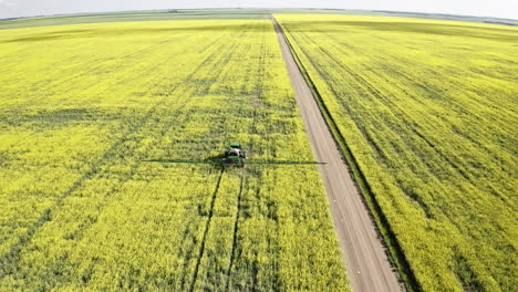 Sprayer-Machinery-At-Work-Spraying-Lush-Canola-Fields-In-Saskatchewan,-Canada---aerial