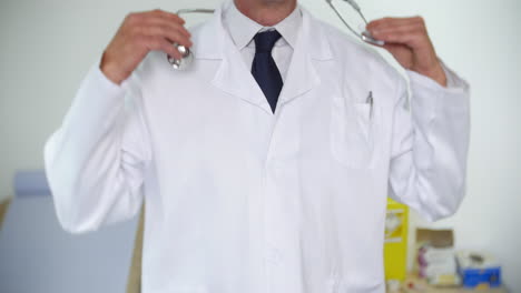 Unrecognizable-doctor-in-a-white-lab-coat-puts-a-stethoscope-around-his-neck