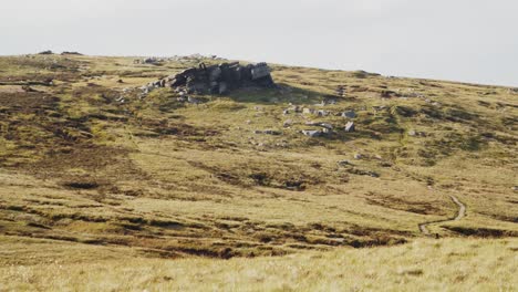 Timelapse-of-sheep-roaming-near-a-jagged-rock-formation-on-rugged-moorland,-Peak-District,-England
