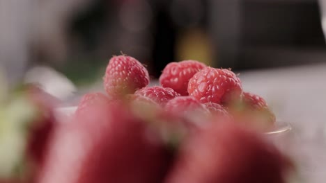Rack-focus-tasty-delicious-strawberry-to-raspberry-fruits-while-cooking-healthy-dessert-close-up-shoot