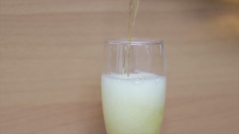 Pouring-beer-in-a-tall-glass-with-the-foam-spilling-down-the-glass