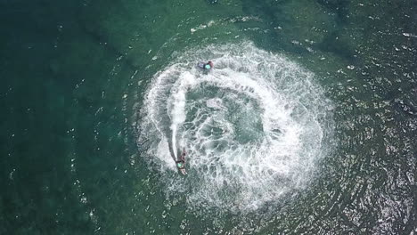 Aerial-Shot,-Two-Jetsurf-Riders-Performing-Action-Maneuvers-In-Ocean