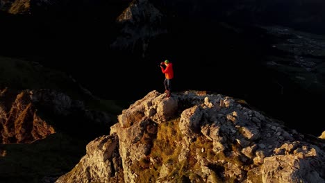 Fotograf-Auf-Dem-Gipfel-Bei-Sonnenaufgang-Drone-Prarallaxe
