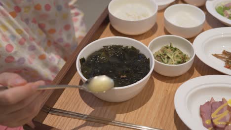 A-New-Mom-trying-Korean-Seaweed-Soup,-A-Post-Natal-Food-In-South-Korea,-hands-closeup