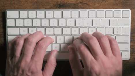 Männliche-Hände,-Die-Text-Auf-Einer-Weißen,-Modernen-Tastatur-Eingeben,-Nahaufnahme