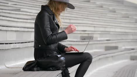 Moving-up-view-shot-of-confident-business-woman-working-outside-with-her-laptop