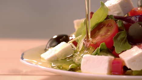 Pouring-olive-oil-dressing-over-fresh-salad,-macro,-slow-motion