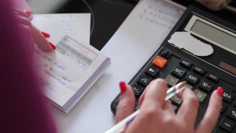 Close-Up-And-Pan-Of-Female-Accountant-Using-Calculator-To-Calculate-Sales-Receipts