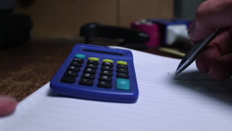 making-calculations-and-adding-up-on-a-notepad-with-a-pen-and-calculator