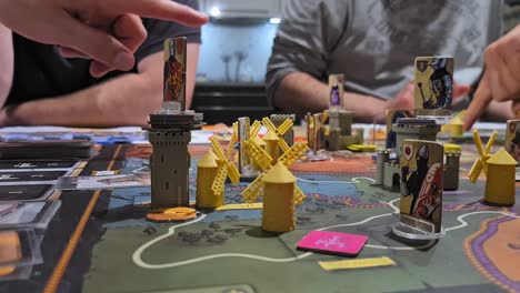 Fief-Board-Game---Players-Pointing-On-The-Components-On-The-Game-Board---close-up