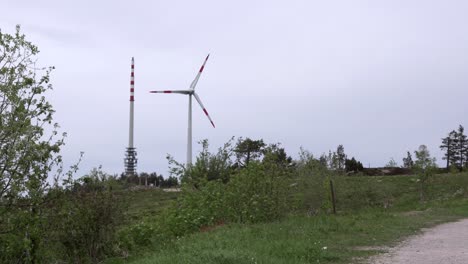Windmill-and-radio-tower-next-to-a-hiking-trail,-Black-Forest,-Germany