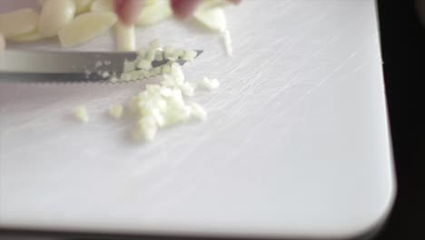 Slicing-onion-on-very-small-pieces-on-a-chopping-board