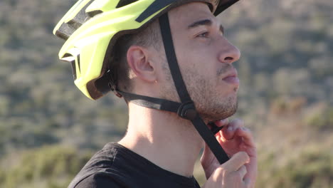 Closeup-of-biker-on-holiday-wears-yellow-helmet-on-sunny-day,-Sardinia