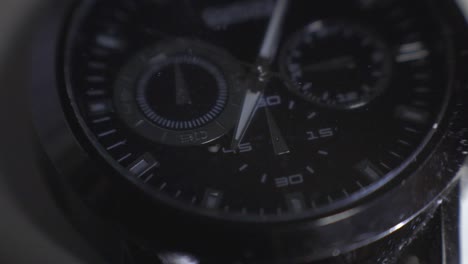 Light-Reflecting-On-The-Glass-And-Steel-Frame-Of-A-Black-Wristwatch---close-up