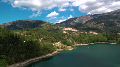 Aerial-parallax-shot-of-Lake-Tsivlou-with-mountains-surrounding-peacefully-the-natural-waters-on-an-overcast-cloudy-day