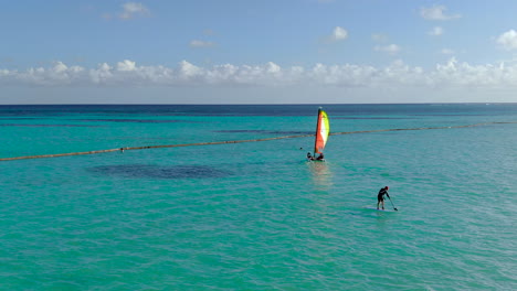 Antenne-Einer-Paddelgrenze-Verläuft-Hinter-Einem-Kleinen-Segelboot,-Dominikanische-Republik