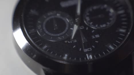 Spotlight-Passing-Through-The-Glass-Of-A-Man's-Watch-With-Hand-Ticking---close-up