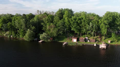 Aerial-wide-shot-of-a-person-fishing-off-lake-dock