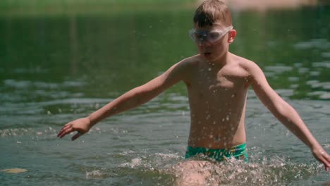 Kid-with-swimwear-in-the-lake-splashing-water-and-walking