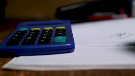 pan-left-to-right-of-a-calculator-and-notepad-and-pen