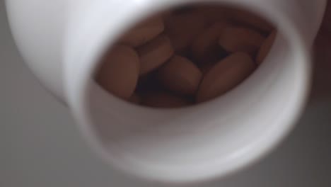 Braun-überzogene-Pillen,-Die-Aus-Einer-Weißen-Flasche-Verschüttet-Werden