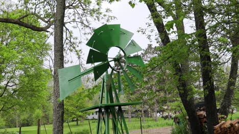 Wind-turning-a-small-green-lawn-windmill-in-countryside