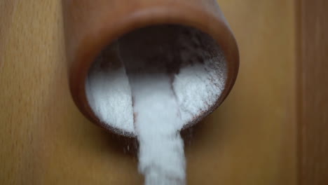 Rice-flour-puring-out-of-the-milling-machine-and-falling-into-a-bowl---slow-motion-close-up