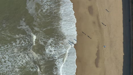 Luftaufnahme-Von-Menschen-Mit-Länglichen-Schatten,-Die-Einen-Tollen-Tag-Am-Strand-Haben