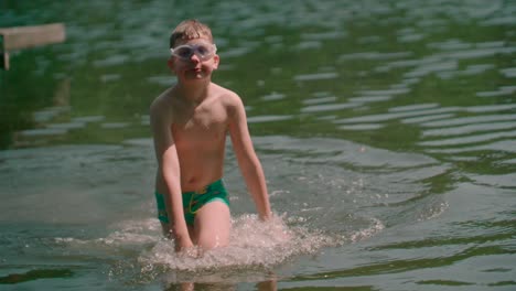 Kid-wearing-short-with-goggles-For-Eye-Protection-walking-into-shore-from-the-lake