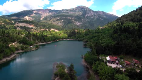Sliding-left-aerial-shot-of-lake-Tsivlou-view-from-above-with-green-mountains-surrounding-peacefully-the-natural-waters