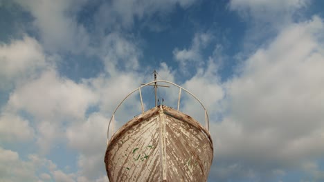 low-angle-shot-of-old-boat-ruin-sky-with-clouds-cinematic-establishment-shot-,-abandoned-wooden-ancient-ship-symmetrical-day-shot