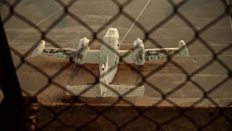 slow-motion-top-shot-of-airplane-on-ground-behind-barbed-wire-netting,-old-abandoned-airplane-cinematic-establishment-shot,-Athens-Elliniko-airport-loneliness