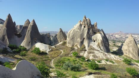 Rock-cut-caves-in-fairy-chimneys-in-Cappadocia-landscape,-backwards-aerial