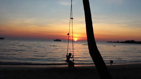 Romantic-Holiday-Scenery-of-Girl-on-Swing-at-the-Beach-during-Sunset