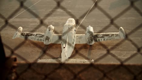 slow-motion-top-shot-of-airplane-on-ground-behind-barbed-wire-netting,-old-abandoned-airplane-cinematic-establishment-shot,-Athens-Elliniko-airport-loneliness-wreck