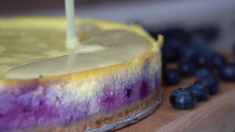 Mesmerizing-view-of-thick-creamy-sauce-covering-top-of-blueberry-cheesecake